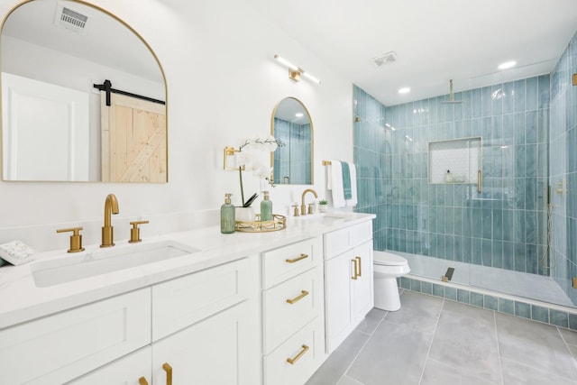 bathroom with toilet, vanity, tile patterned floors, and a shower with shower door