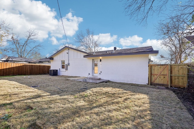 back of house with central AC and a yard