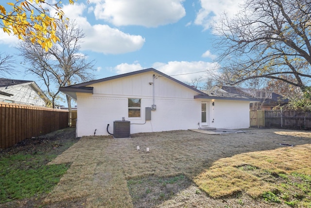 rear view of house featuring a yard and central AC