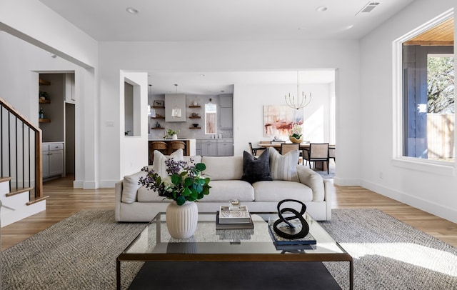 living room with wood-type flooring and an inviting chandelier