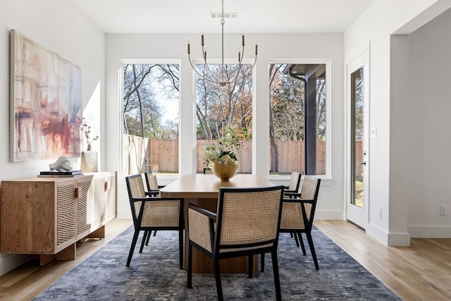 dining room with hardwood / wood-style floors, a notable chandelier, and a wealth of natural light