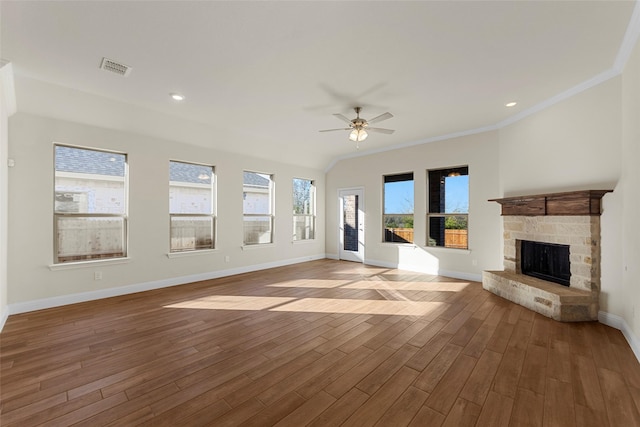 unfurnished living room with hardwood / wood-style floors, ceiling fan, crown molding, and a fireplace