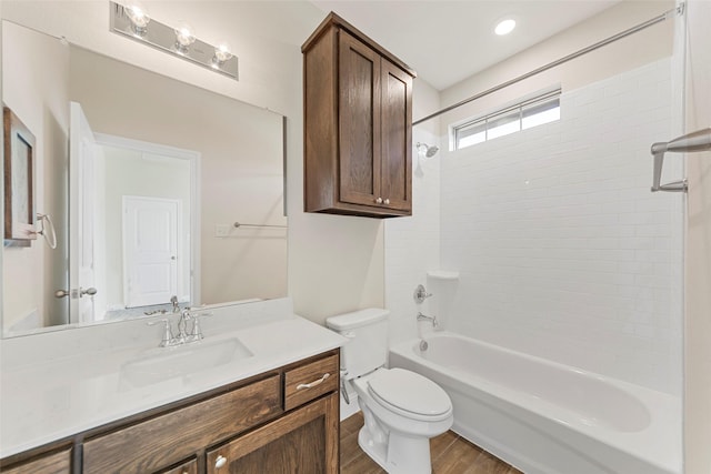 full bathroom featuring toilet, wood-type flooring, vanity, and tiled shower / bath combo