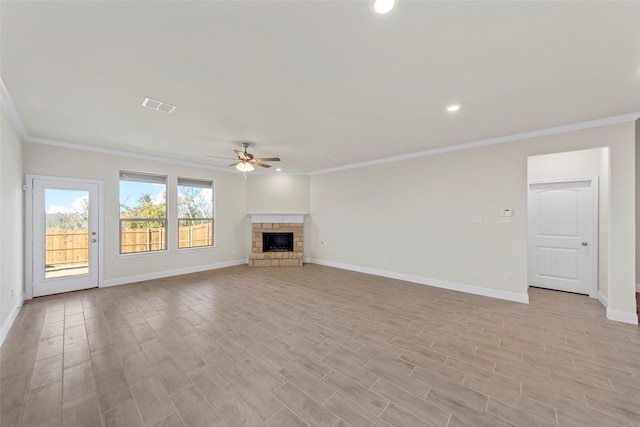 unfurnished living room featuring ceiling fan, crown molding, and a fireplace