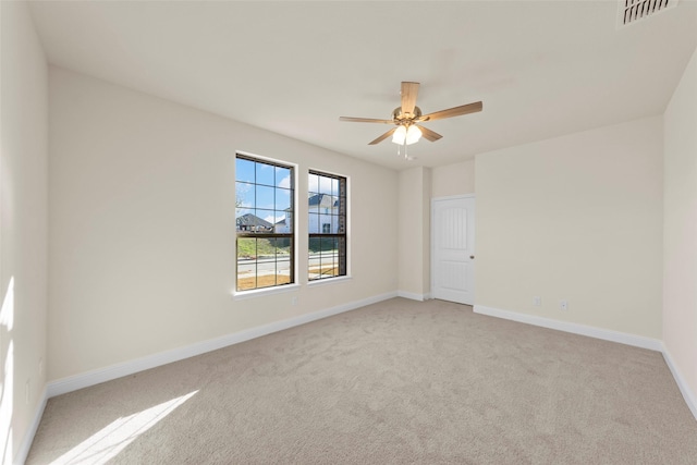 empty room with ceiling fan and light carpet