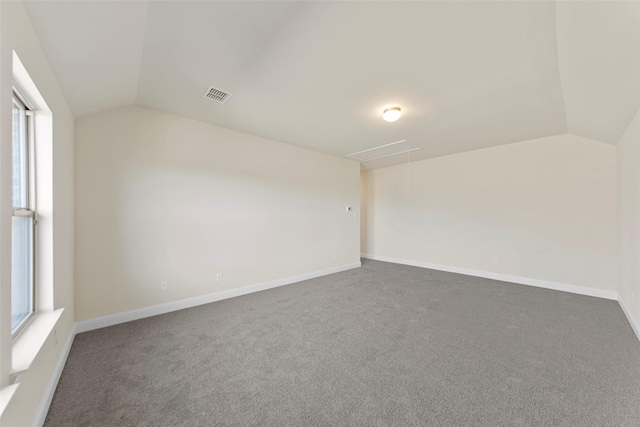 carpeted empty room with lofted ceiling