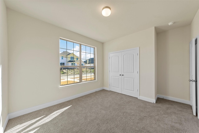 unfurnished bedroom with light carpet and a closet