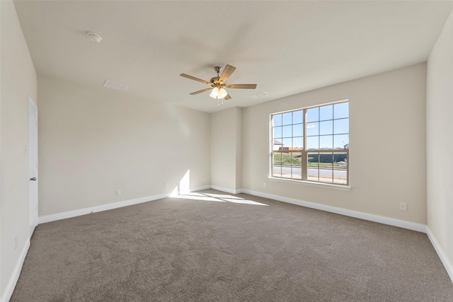 empty room featuring ceiling fan and carpet