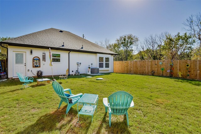 rear view of property featuring cooling unit and a yard