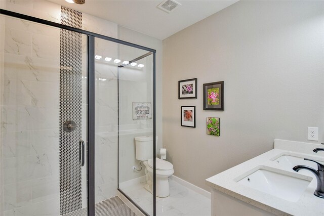 bathroom featuring vanity, toilet, and a shower with shower door