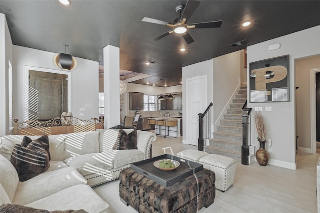 living room featuring ceiling fan and light hardwood / wood-style flooring