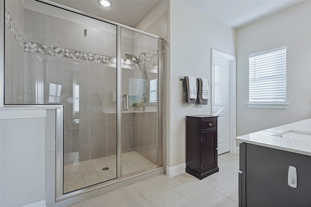 bathroom with a shower with door, tile patterned flooring, and vanity