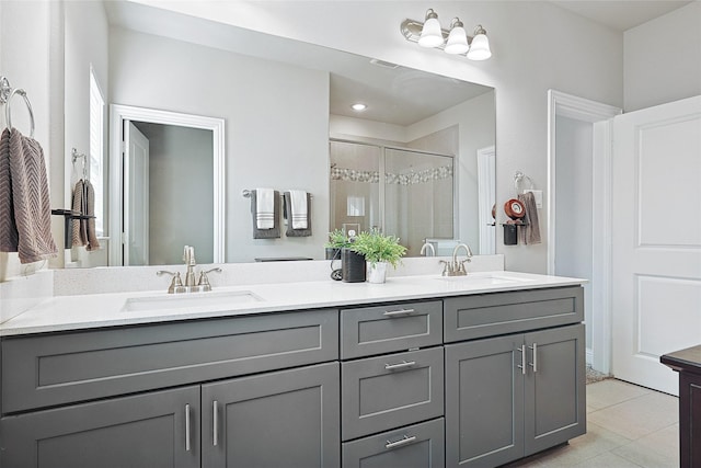 bathroom featuring a shower with door, vanity, and tile patterned floors