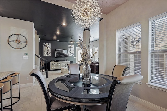 dining room featuring ceiling fan with notable chandelier