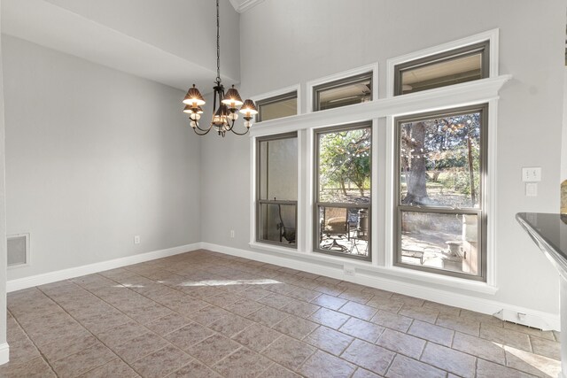 unfurnished dining area featuring a notable chandelier and vaulted ceiling