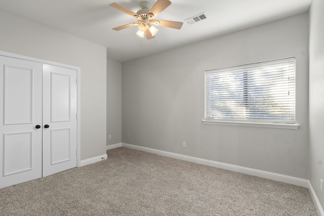 unfurnished bedroom with ceiling fan, a closet, and carpet floors