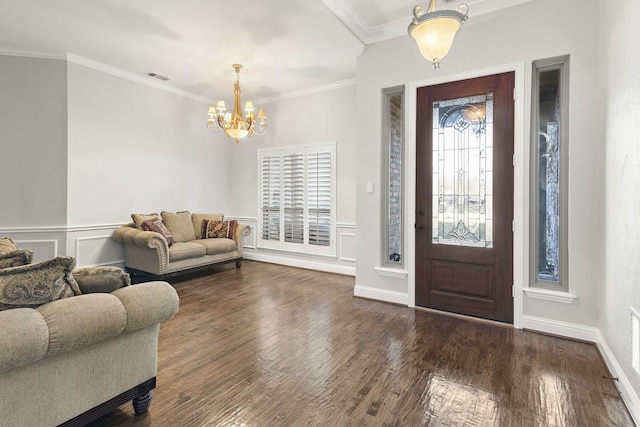 foyer entrance with a chandelier, dark hardwood / wood-style flooring, and ornamental molding