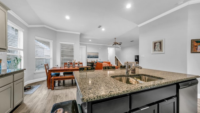 kitchen with gray cabinetry, ceiling fan, sink, light hardwood / wood-style floors, and a center island with sink