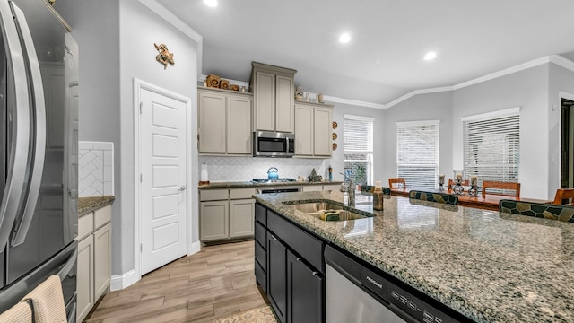 kitchen with crown molding, sink, decorative backsplash, light wood-type flooring, and stainless steel appliances