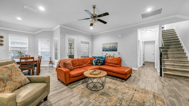 living room with crown molding, light hardwood / wood-style flooring, and ceiling fan