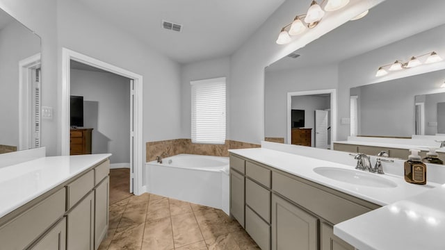 bathroom with tile patterned flooring, vanity, and a bathtub