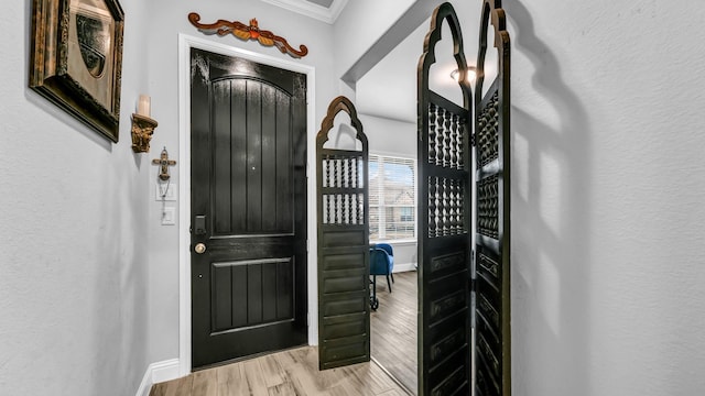 entryway with crown molding and light hardwood / wood-style flooring