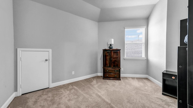 interior space featuring light carpet and vaulted ceiling