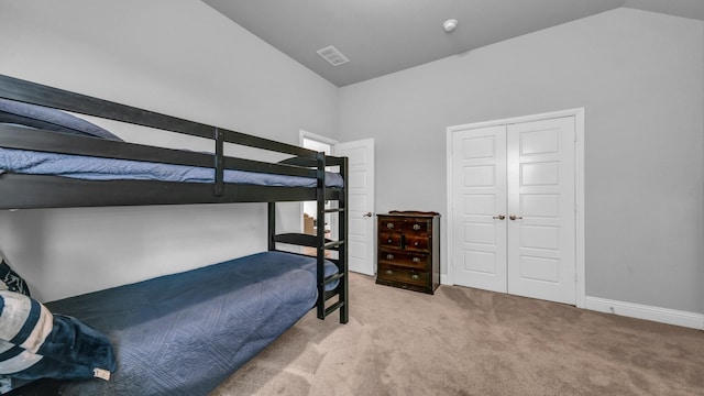 carpeted bedroom featuring a closet and lofted ceiling