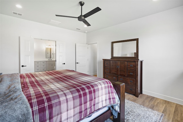 bedroom featuring connected bathroom, ceiling fan, sink, and hardwood / wood-style flooring