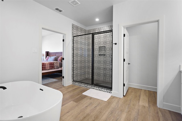 bathroom featuring plus walk in shower and hardwood / wood-style flooring