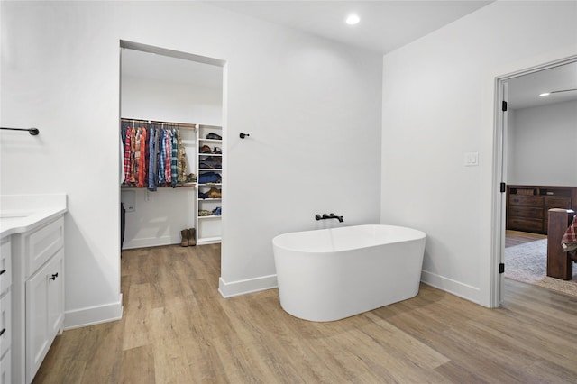 bathroom featuring hardwood / wood-style floors, vanity, and a tub