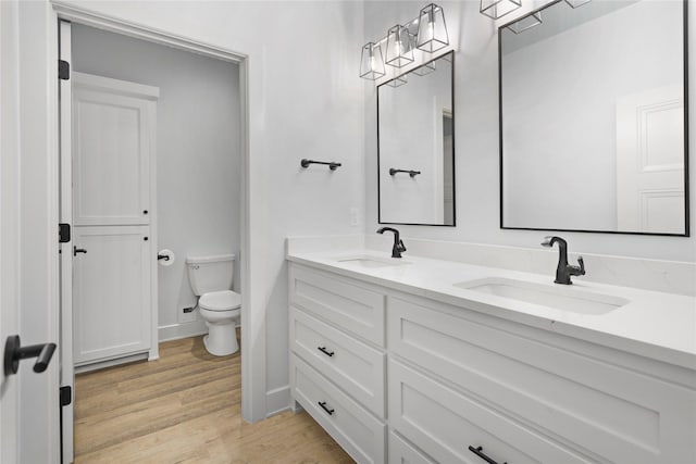 bathroom with hardwood / wood-style floors, vanity, and toilet