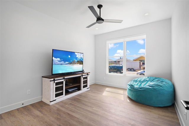 living area featuring hardwood / wood-style flooring and ceiling fan