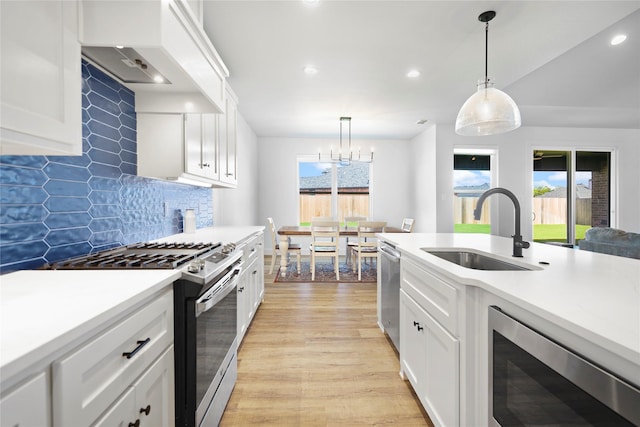 kitchen with white cabinets, appliances with stainless steel finishes, a healthy amount of sunlight, and sink