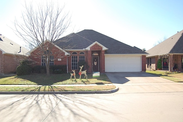 view of front of property featuring a garage, concrete driveway, and brick siding