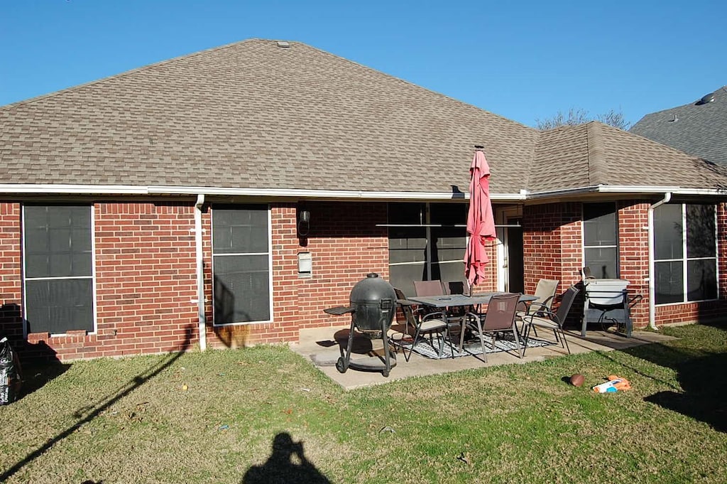 rear view of house with a patio area and a yard