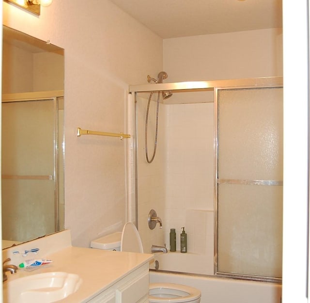 full bath featuring shower / bath combination with glass door, vanity, and toilet