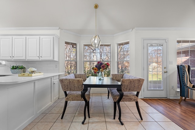 dining area with crown molding, plenty of natural light, and light wood-type flooring