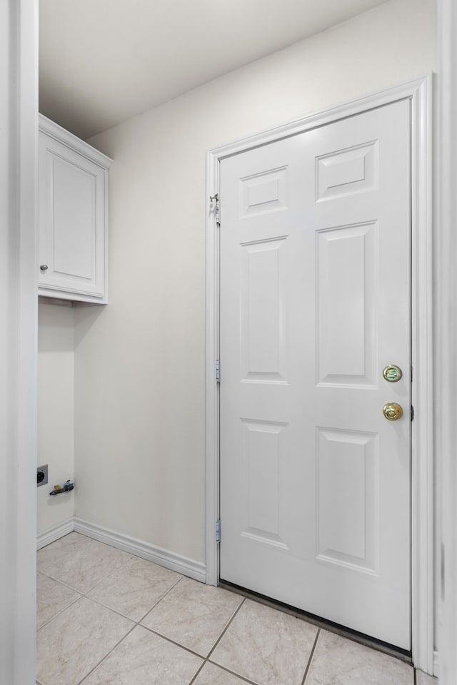 laundry room with cabinets, light tile patterned floors, and hookup for an electric dryer