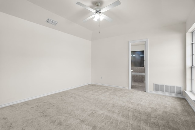 carpeted spare room featuring ceiling fan and a wealth of natural light