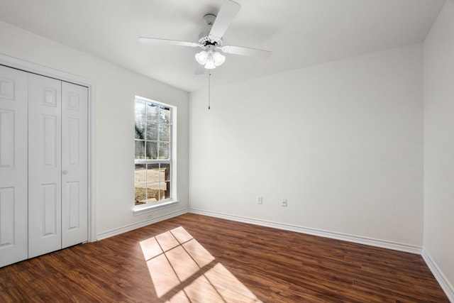 unfurnished bedroom with a closet, dark hardwood / wood-style floors, and ceiling fan