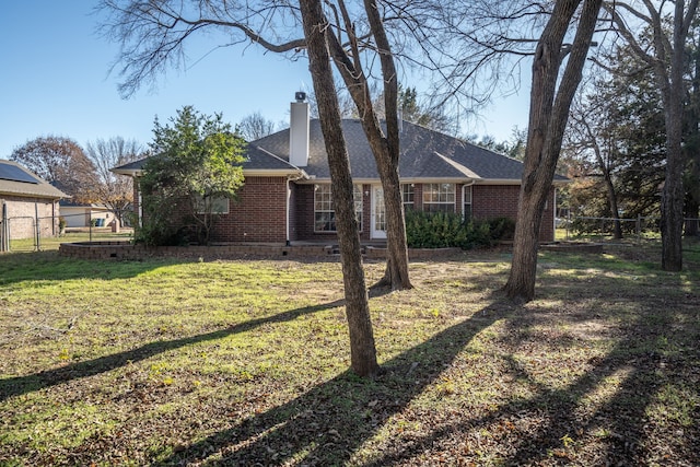 rear view of house featuring a lawn