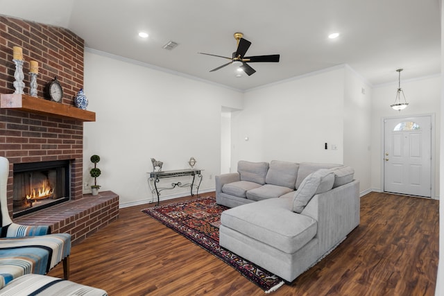 living room with a fireplace, ceiling fan, dark hardwood / wood-style flooring, and ornamental molding