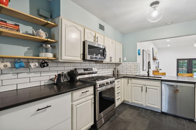 kitchen featuring tasteful backsplash, white cabinetry, sink, and appliances with stainless steel finishes