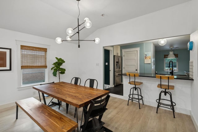 dining room featuring a wealth of natural light, sink, and lofted ceiling