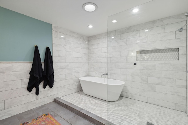 bathroom with tile patterned floors, separate shower and tub, and tile walls