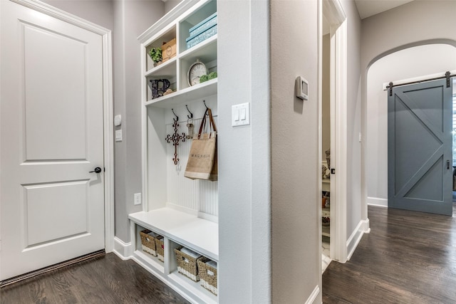 mudroom with dark hardwood / wood-style floors and a barn door