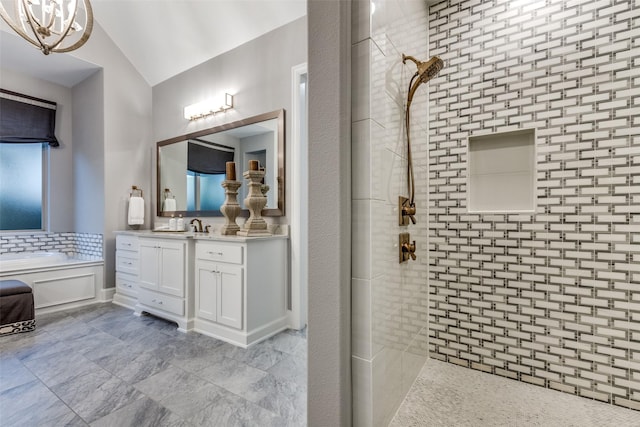 bathroom featuring independent shower and bath, vaulted ceiling, and vanity