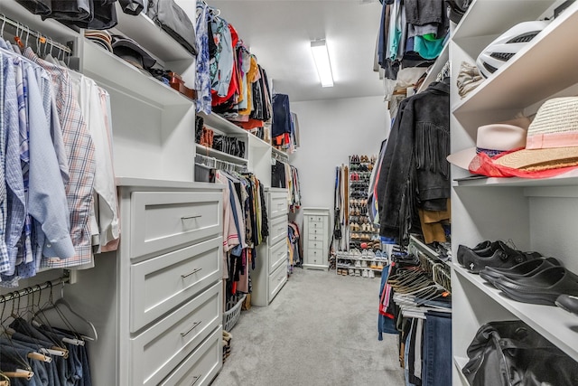 walk in closet with light carpet