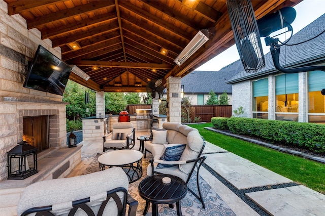 view of patio with a gazebo, an outdoor stone fireplace, and exterior kitchen